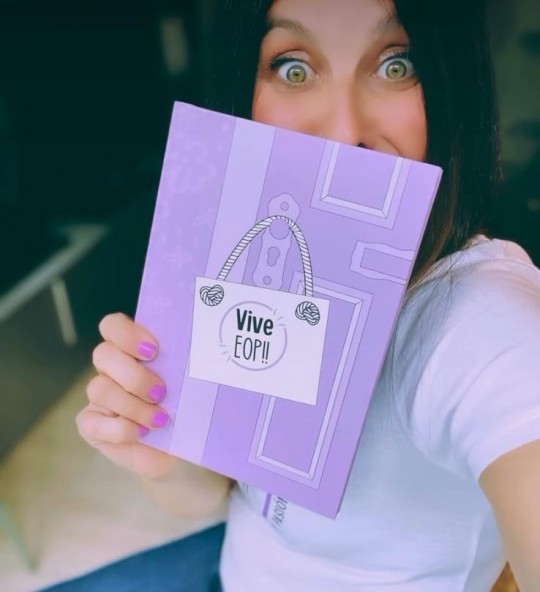 Mujer sosteniendo el libro Vive EOP!! con una sonrisa