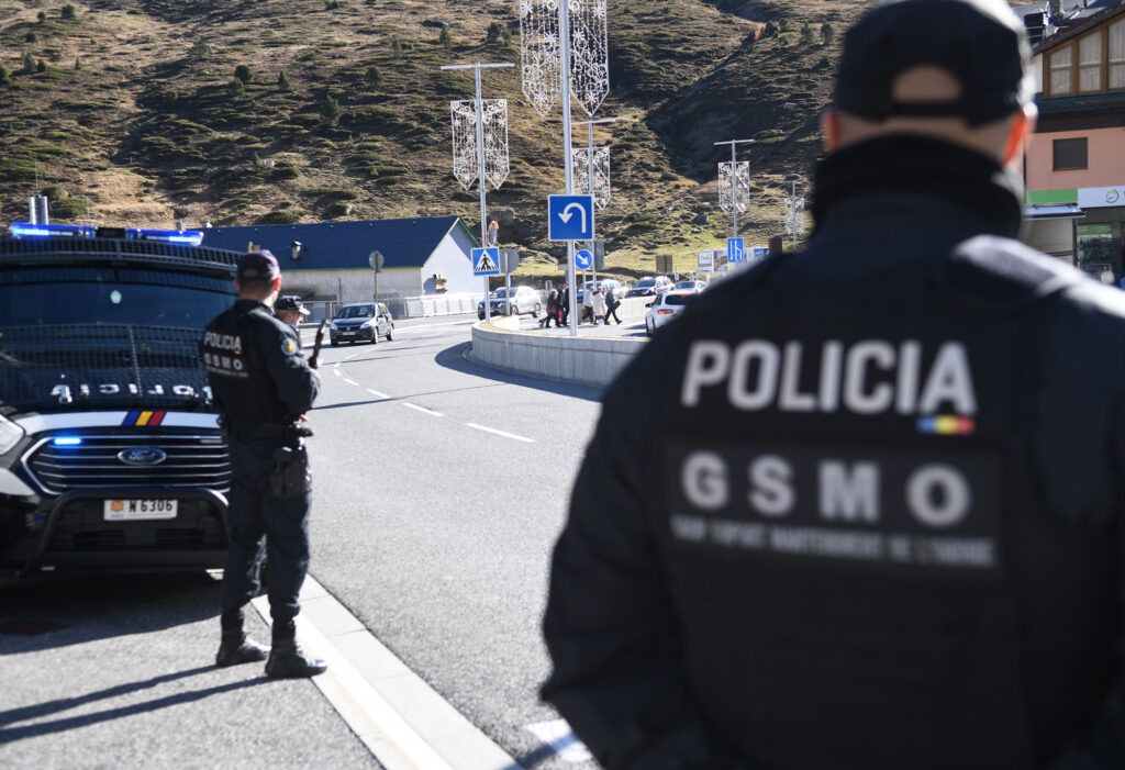 Policía en una carretera con vehículos y paisaje montañoso al fondo