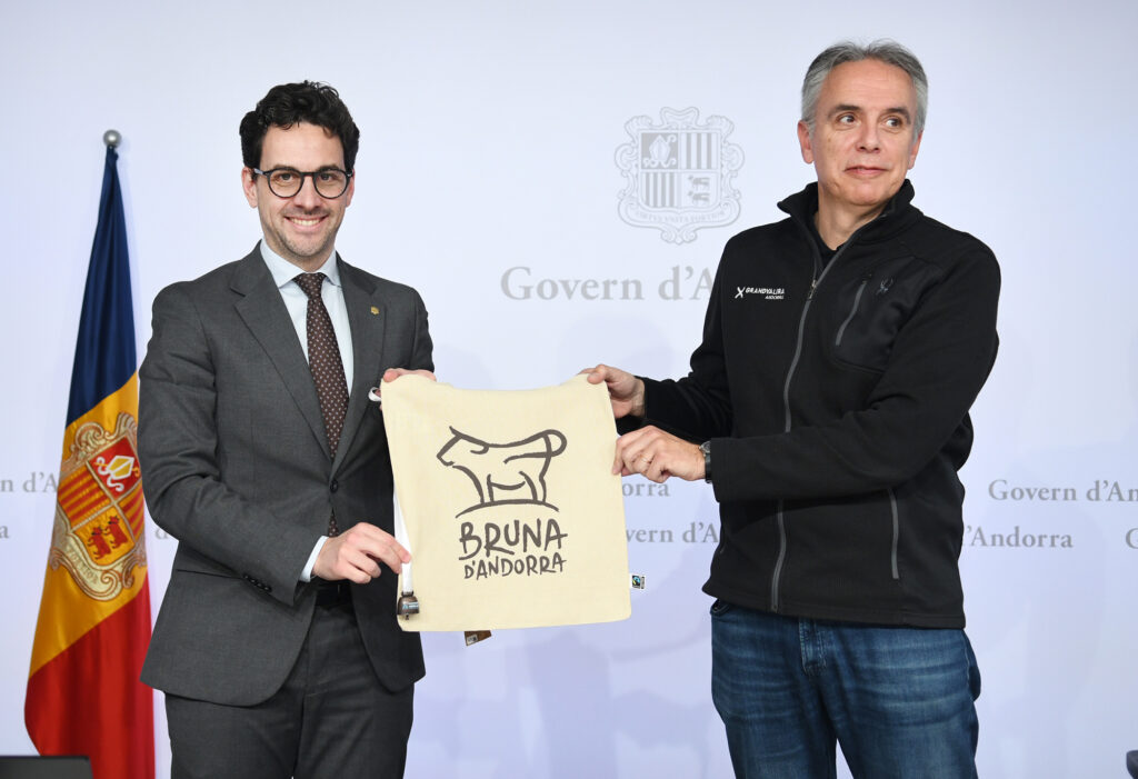 Dos hombres sosteniendo una bolsa con el logo de la Vaca Bruna d'Andorra