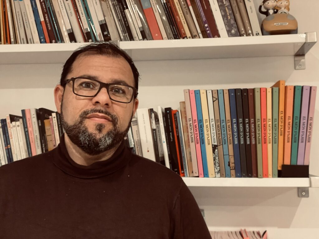 Toni Mata posando frente a una estantería llena de libros