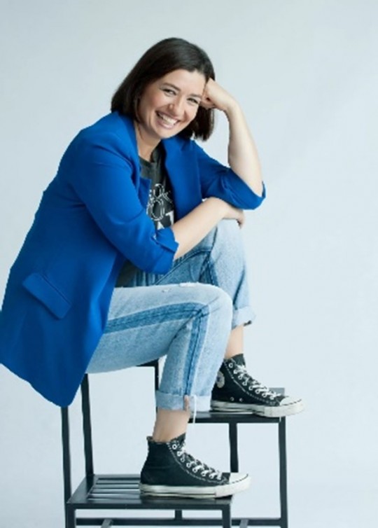 Sara Desirée Ruiz sonriendo mientras se sienta en una silla
