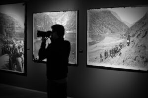 Una persona fotografiando exposiciones de fotografías históricas