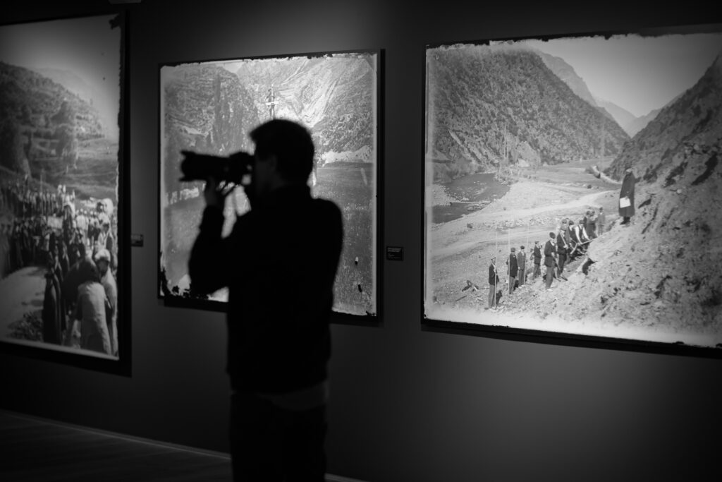 Una persona fotografiando exposiciones de fotografías históricas