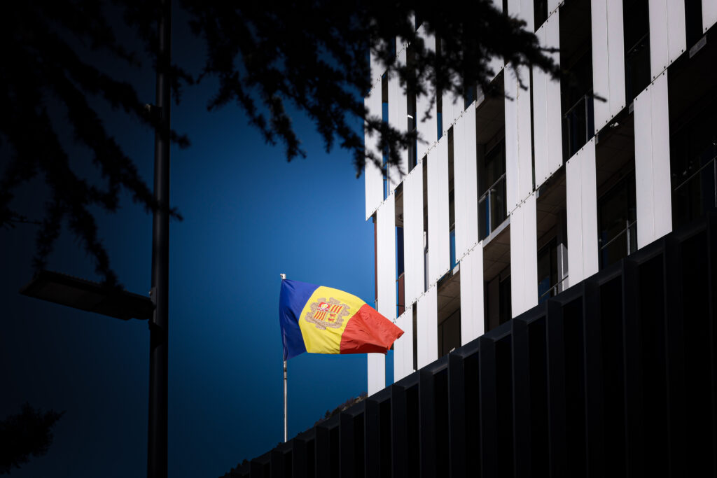 Bandera de Andorra ondeando frente a un edificio moderno