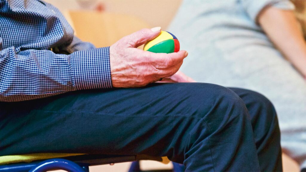 Persona mayor sosteniendo una pelota de colores en un centro sociosanitario