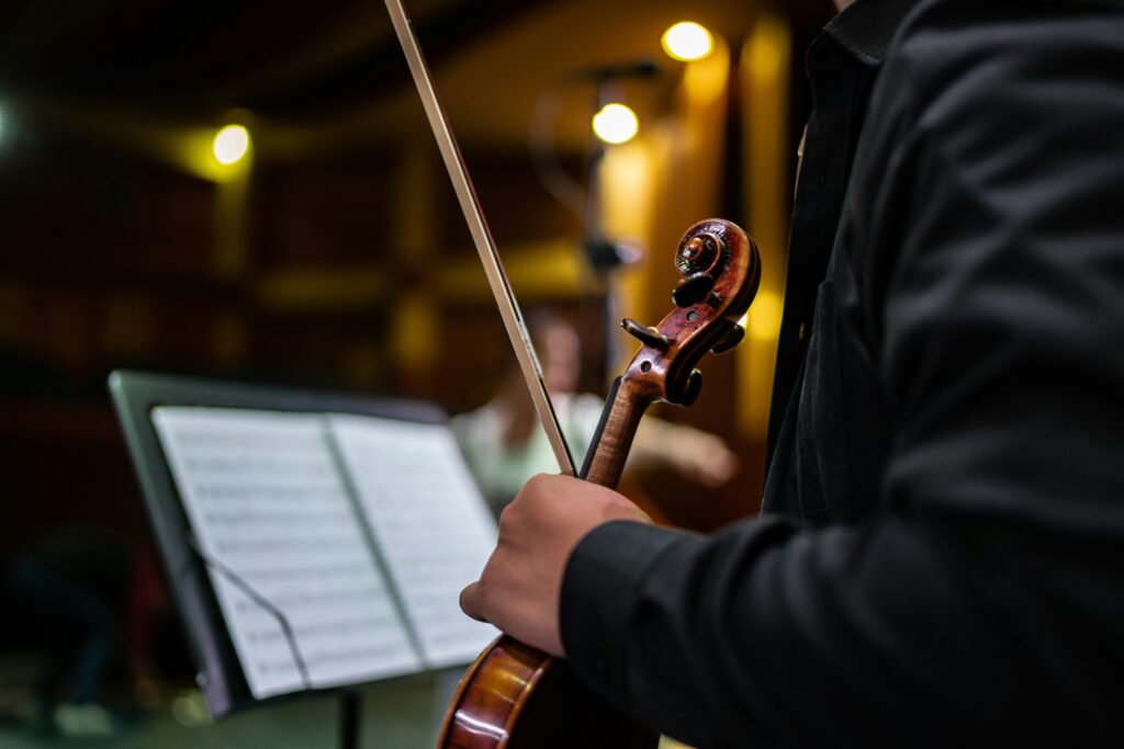 Músico sosteniendo un violín en un concierto de la ONCA