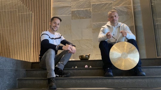 Dos facilitadores en una sesión de música con bols de quars y gongs