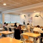 Estudiantes realizando un examen oficial de lengua catalana A1 en un aula