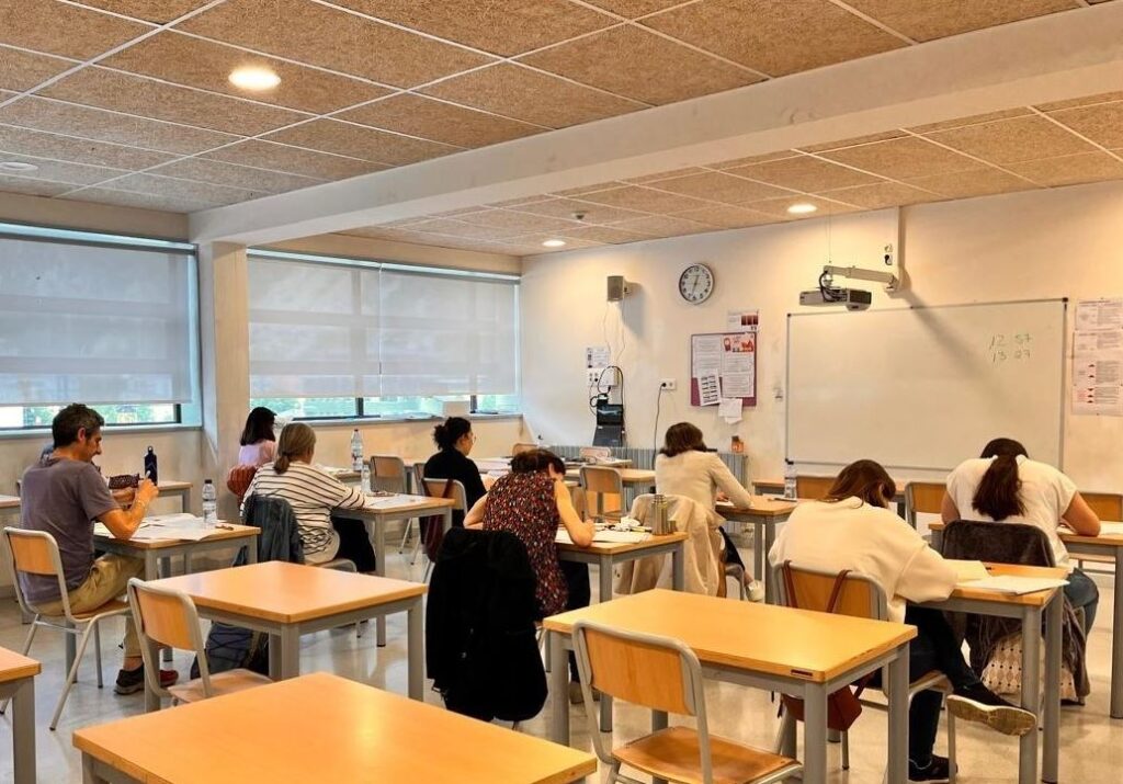 Estudiantes realizando un examen oficial de lengua catalana A1 en un aula