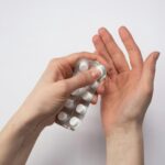 Persona abriendo un blíster de pastillas en una mano