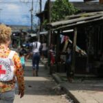Persona con mochila de la Cruz Roja caminando por una calle en Congo
