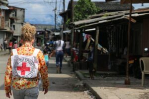 Persona con mochila de la Cruz Roja caminando por una calle en Congo