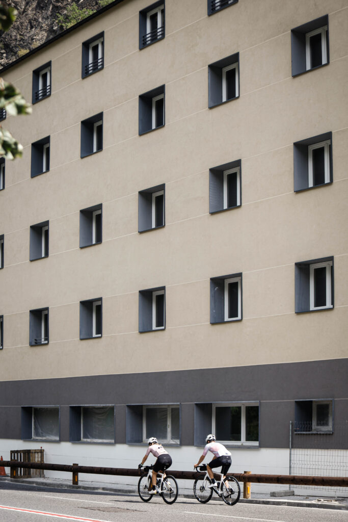 Dos ciclistas pasan frente al edificio Font de Ferro en Aixovall.