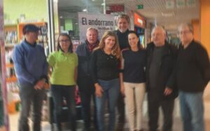 Grupo de personas en un evento en Andorra con carteles de fondo