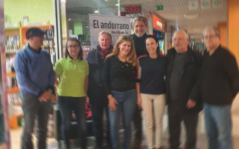 Grupo de personas en un evento en Andorra con carteles de fondo