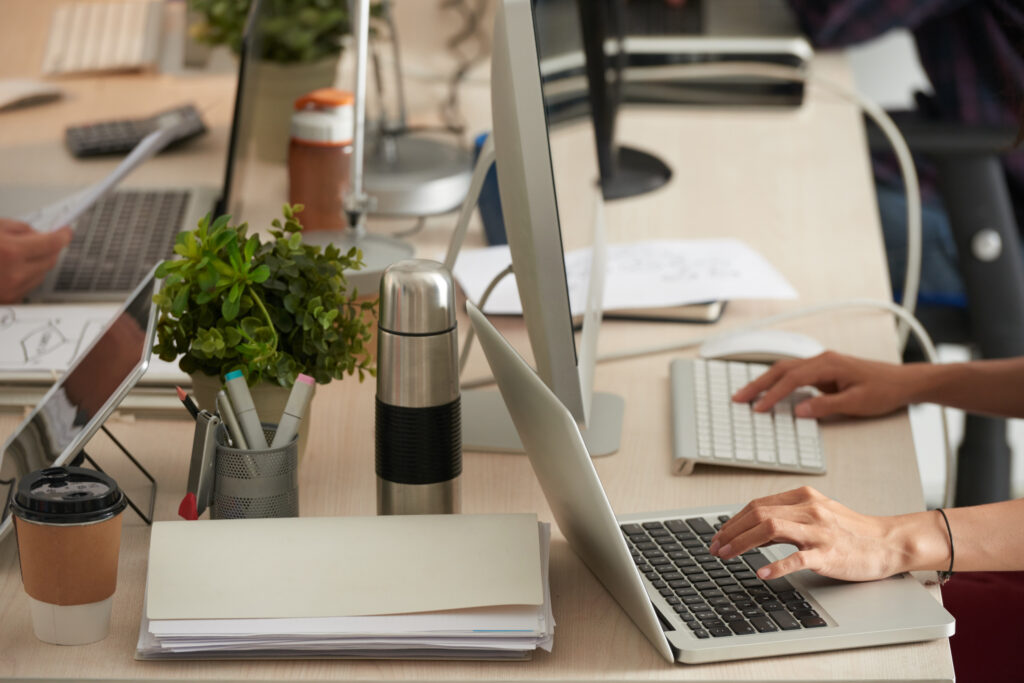 Persona trabajando en oficina con computadora y documentos
