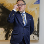Xavier Espot en una reunión, vestido con traje y gafas.