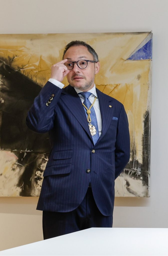 Xavier Espot en una reunión, vestido con traje y gafas.