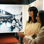 Inauguració de l'exposició World Press Photo a Andorra amb dues dones conversant.