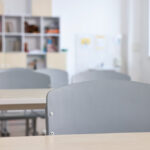 Aula vacía con mesas y sillas preparadas para estudiantes.