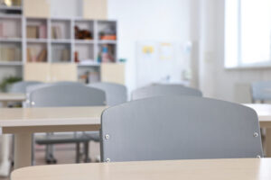 Aula vacía con mesas y sillas preparadas para estudiantes.