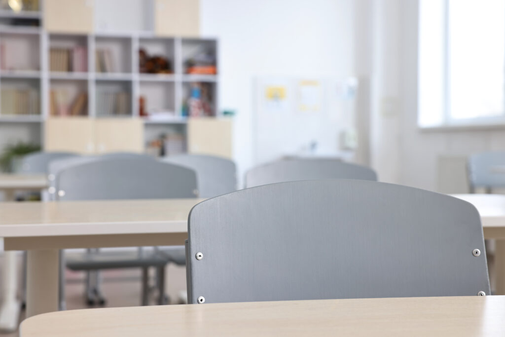 Aula vacía con mesas y sillas preparadas para estudiantes.