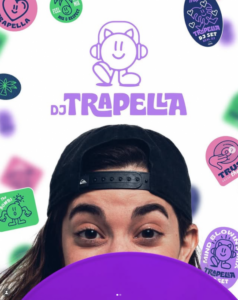 DJ Trapella en un evento musical con elementos gráficos coloridos