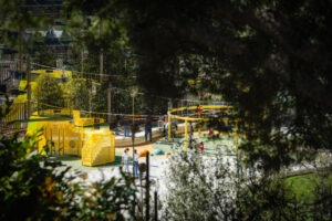Parque infantil en Andorra con niños jugando y estructuras amarillas