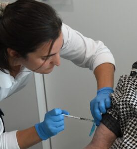 Infermera administrant una injecció a un pacient amb guants de làtex.