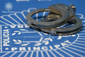 Esposas sobre un fondo con el logo de la policía de Andorra