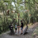 Familia disfrutando de una actividad en el bosque con esculturas de insectos