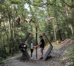 Familia disfrutando de una actividad en el bosque con esculturas de insectos