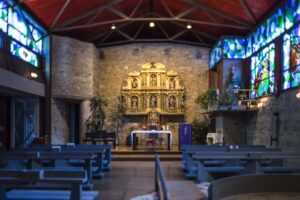 Interior de la iglesia de Santa Eulàlia d'Encamp con altar y vitrales coloridos