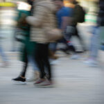 Personas caminando en una calle con movimiento difuminado