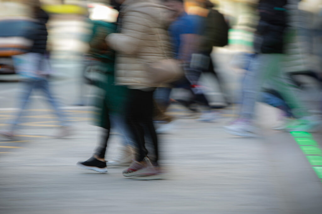 Personas caminando en una calle con movimiento difuminado