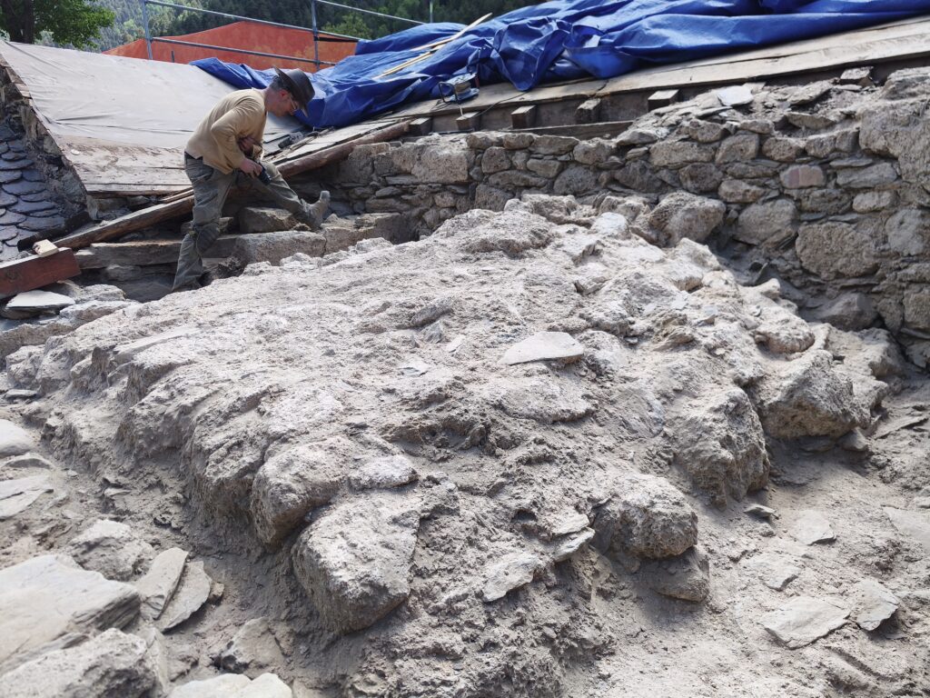 Trabajador realizando excavaciones en la iglesia románica de Sant Martí de la Cortinada