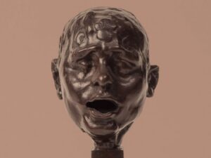 Escultura moderna de un rostro expresivo en la exposición nocturna
