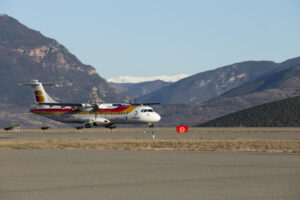 Avión en la pista del aeropuerto de Andorra-La Seu con montañas al fondo