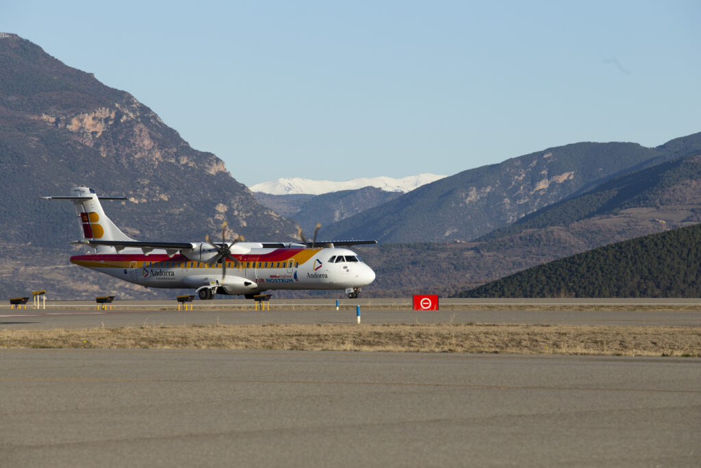 Avión en la pista del aeropuerto de Andorra-La Seu con montañas al fondo