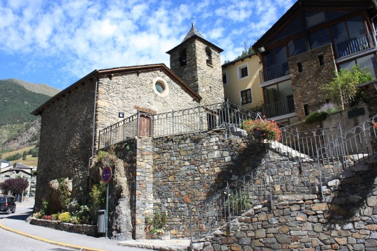 Iglesia de piedra en el pueblo de Arinsal con paisaje montañoso