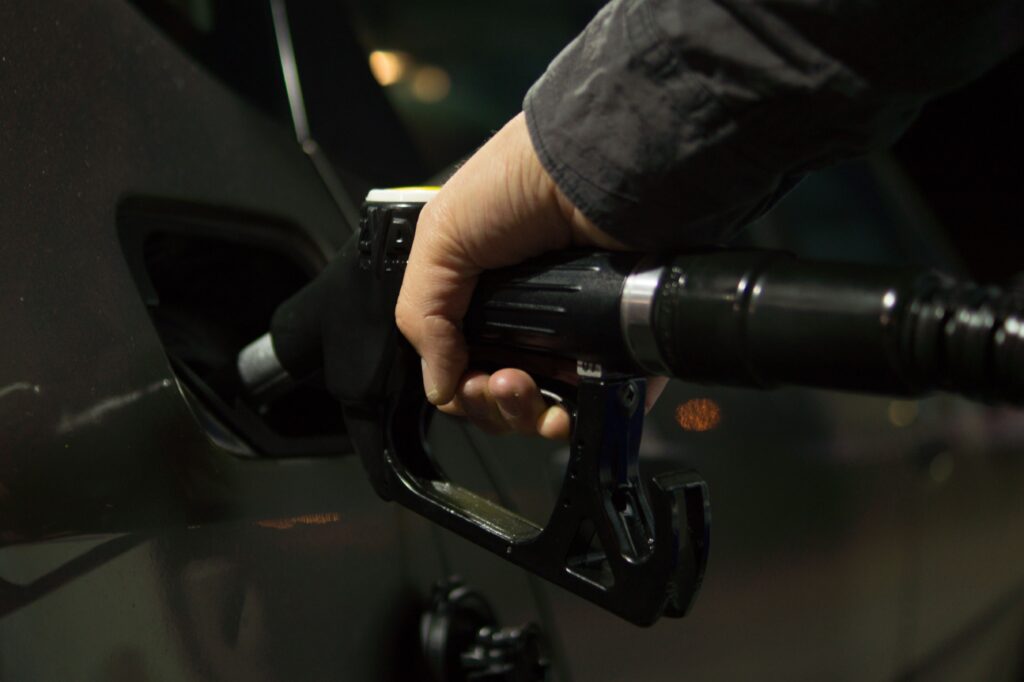 Persona llenando un tanque de combustible en una gasolinera