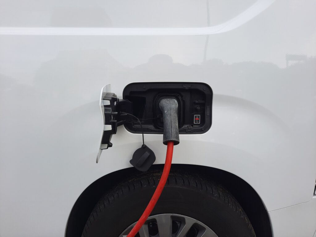 Conector de carga de un vehículo eléctrico en una estación de carga.