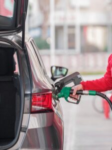 Persona repostando gasoil en un coche en una gasolinera.