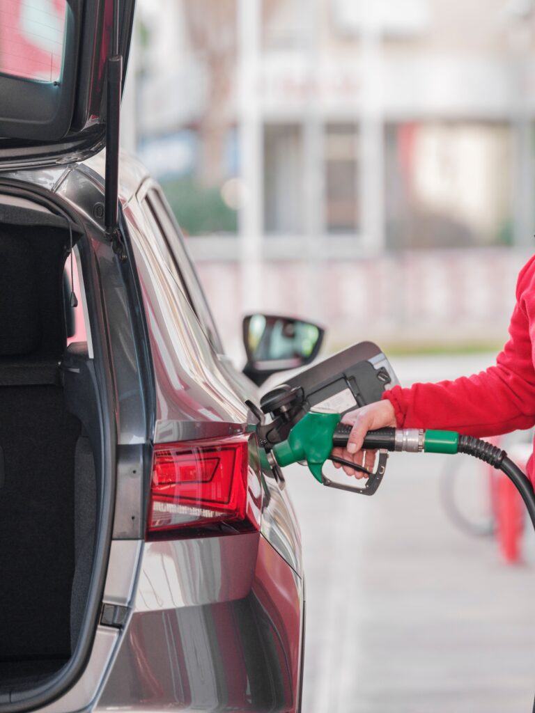 Persona repostando gasoil en un coche en una gasolinera.