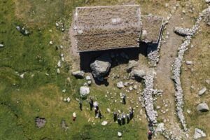 Vista aérea de un yacimiento arqueológico en Encamp con personas trabajando.