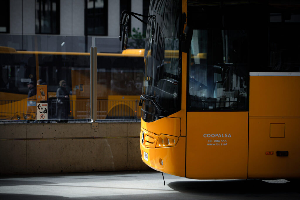 Autobús amarillo visto de cerca junto a una marquesina acristalada