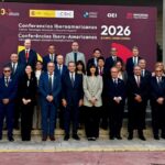 Grupo de asistentes posa ante el cartel de las Conferencias Iberoamericanas de 2026 en Alicante.