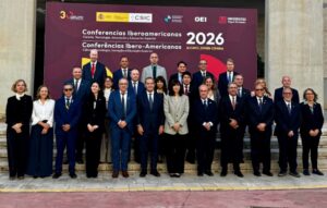Grupo de asistentes posa ante el cartel de las Conferencias Iberoamericanas de 2026 en Alicante.