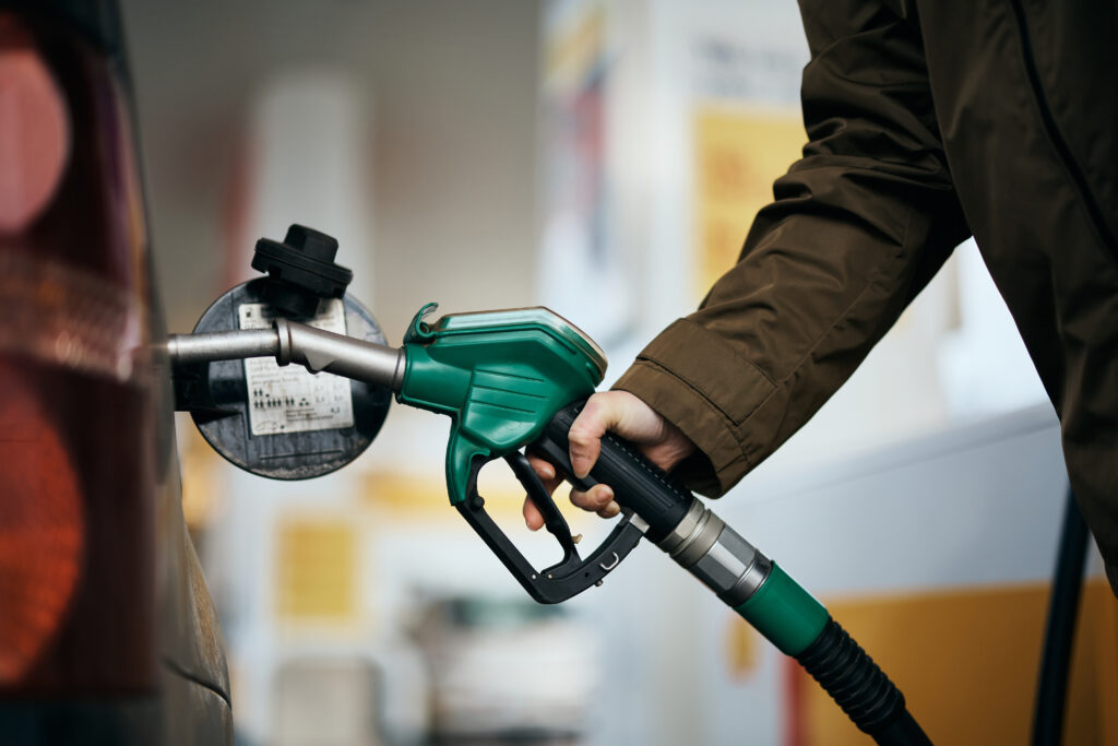 Persona llenando un vehículo con gasolina en una estación de servicio