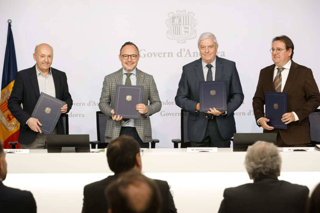 Cuatro hombres muestran carpetas ante el emblema del Govern d’Andorra.
